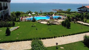 A resort with a swimming pool, a view of the sea, and well-maintained lawns. - MONASTERY Apart Complex (Sveti Vlas)