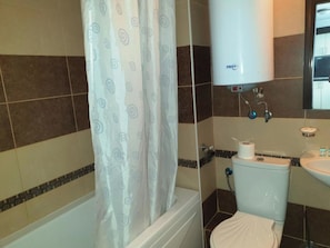 A bathroom with a bathtub, toilet, and sink. - MONASTERY Apart Complex (Sveti Vlas)