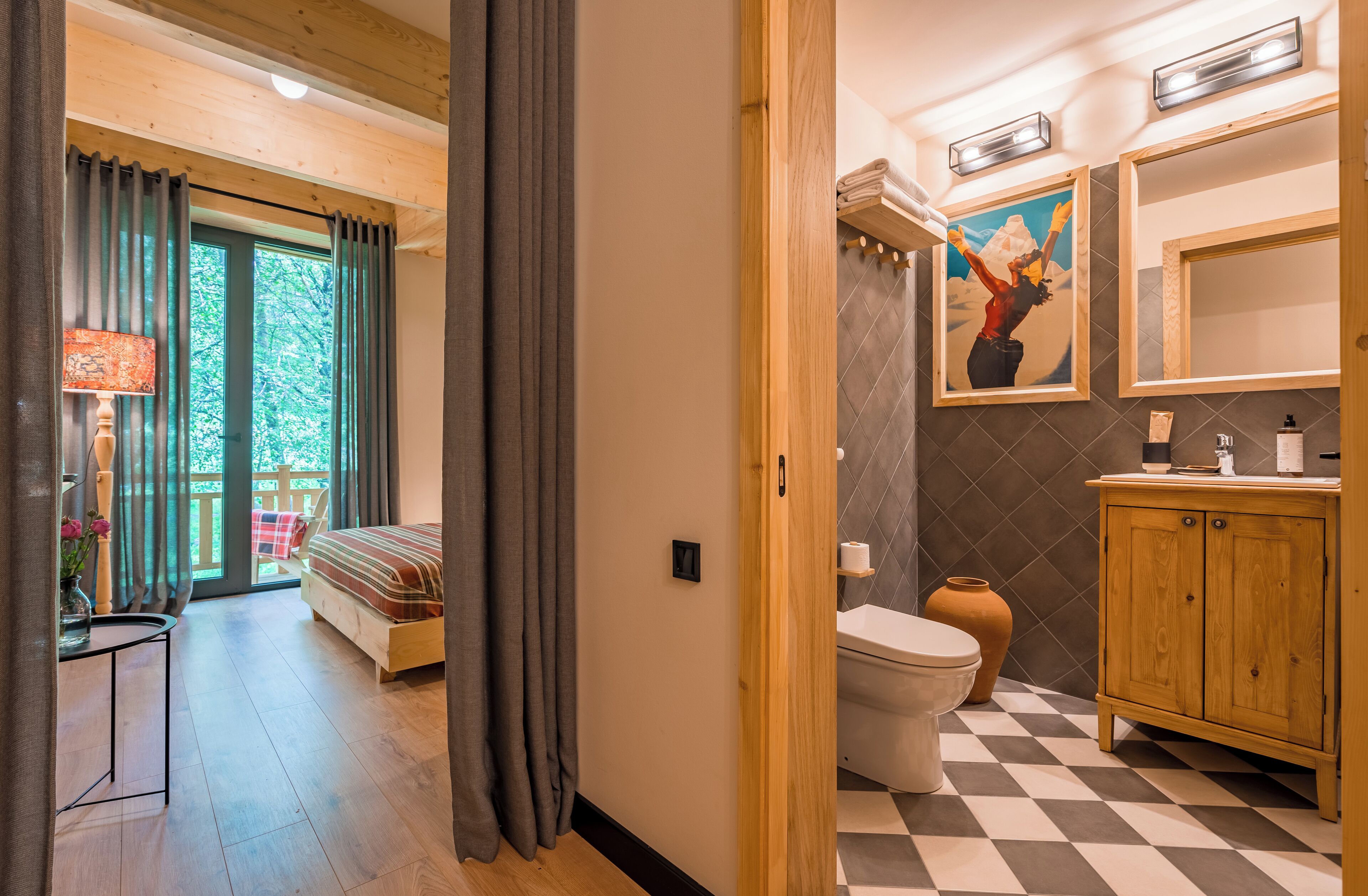 A bedroom with a bed, a bedside table, and a view of a balcony.