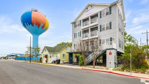A multi-story building with a balcony, a water tower, and a street view. - Downtown OC Townhome! - (B) (Ocean City)