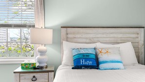 A bedroom with a bed, a nightstand, a lamp, and a window with blinds. - Downtown OC Townhome! (A) (Ocean City)