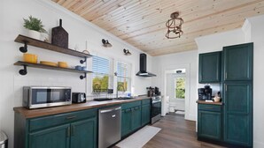 A modern kitchen with green cabinets, a wooden ceiling, and a built-in microwave. - Walk to State Street - Remodeled Home (Bristol)