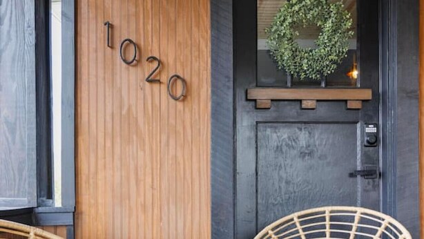 A wooden door with the number 1020, a small potted plant, and two wicker chairs on a wooden deck. - Walk to State Street - Remodeled Home (Bristol)