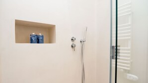 Ein Badezimmer mit Dusche, Glasabtrennung und zwei Shampoo-Flaschen.