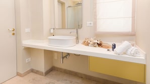 A modern bathroom with a white sink, a mirror, and a window. - Marina Homes Standard 2 (Syracuse)