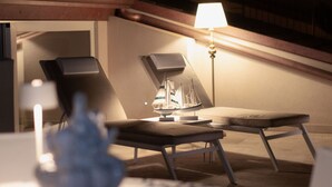 Une chambre moderne avec un canapé, une petite table et une maquette de bateau décorative.