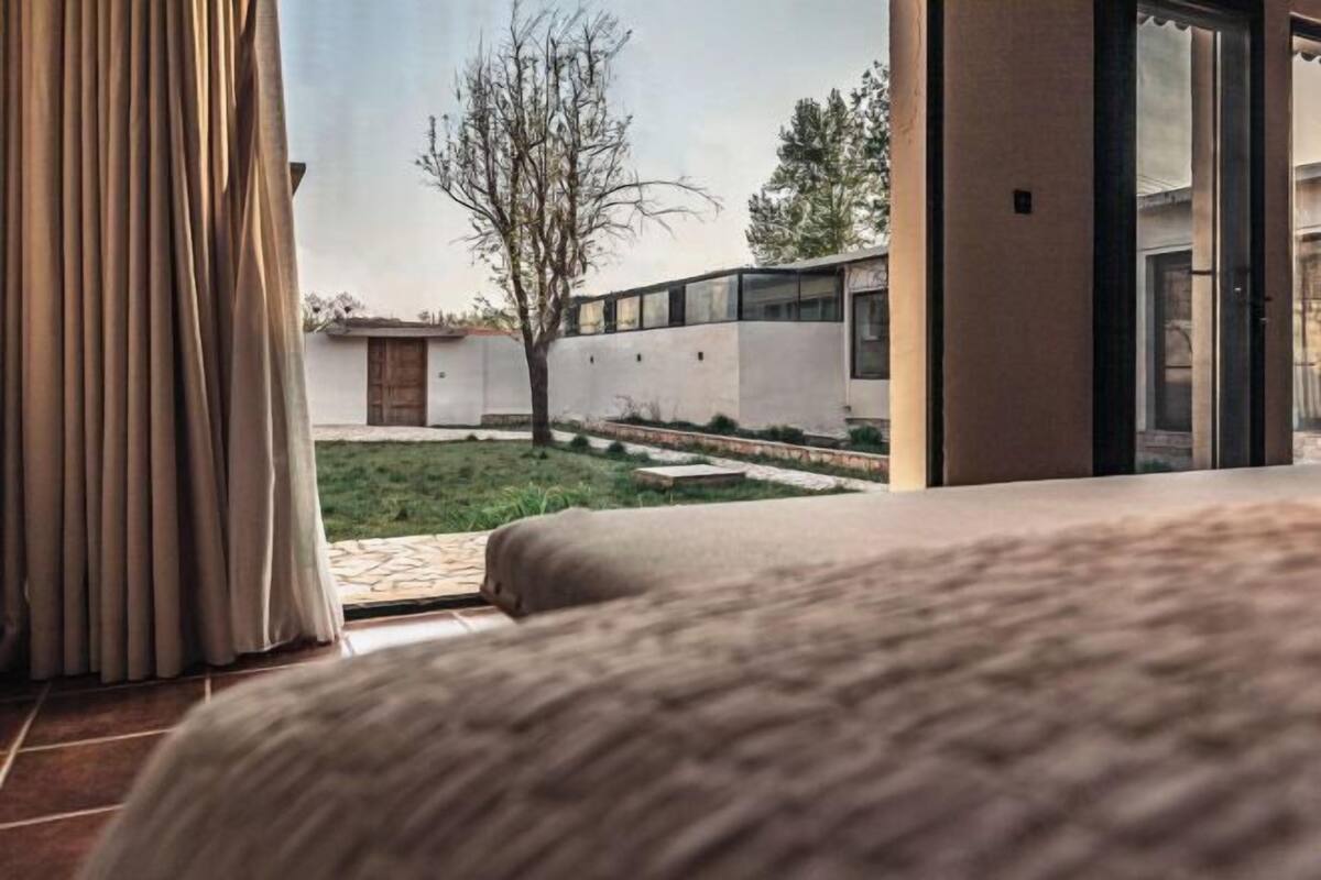 A bedroom with a view of a courtyard, a window, and a door.