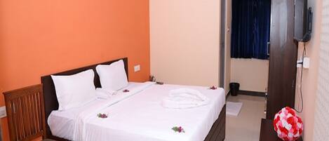 A bedroom with a wooden bed, a chair, an air conditioning unit, and a television.