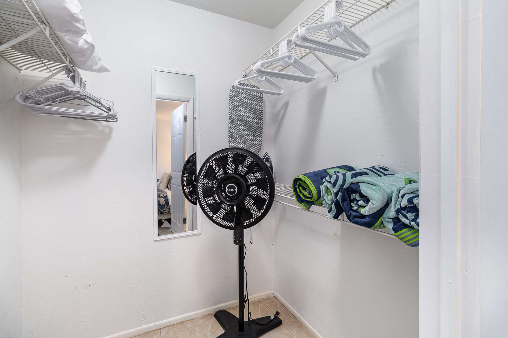 Un espace dédié à la lessive, équipé d’un ventilateur fixé au mur, de supports à linge et d’une fenêtre.