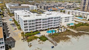 A multi-story hotel with a rooftop pool, a beachside location, and a parking lot. - Pelican Landing Unit 330 - Ocean view (Myrtle Beach)