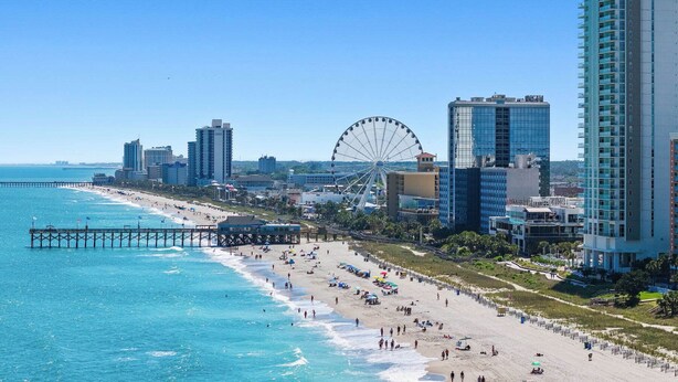 A coastal cityscape with a beach, a pier, and a large Ferris wheel. - Pelican Landing Unit 330 - Ocean view (Myrtle Beach)