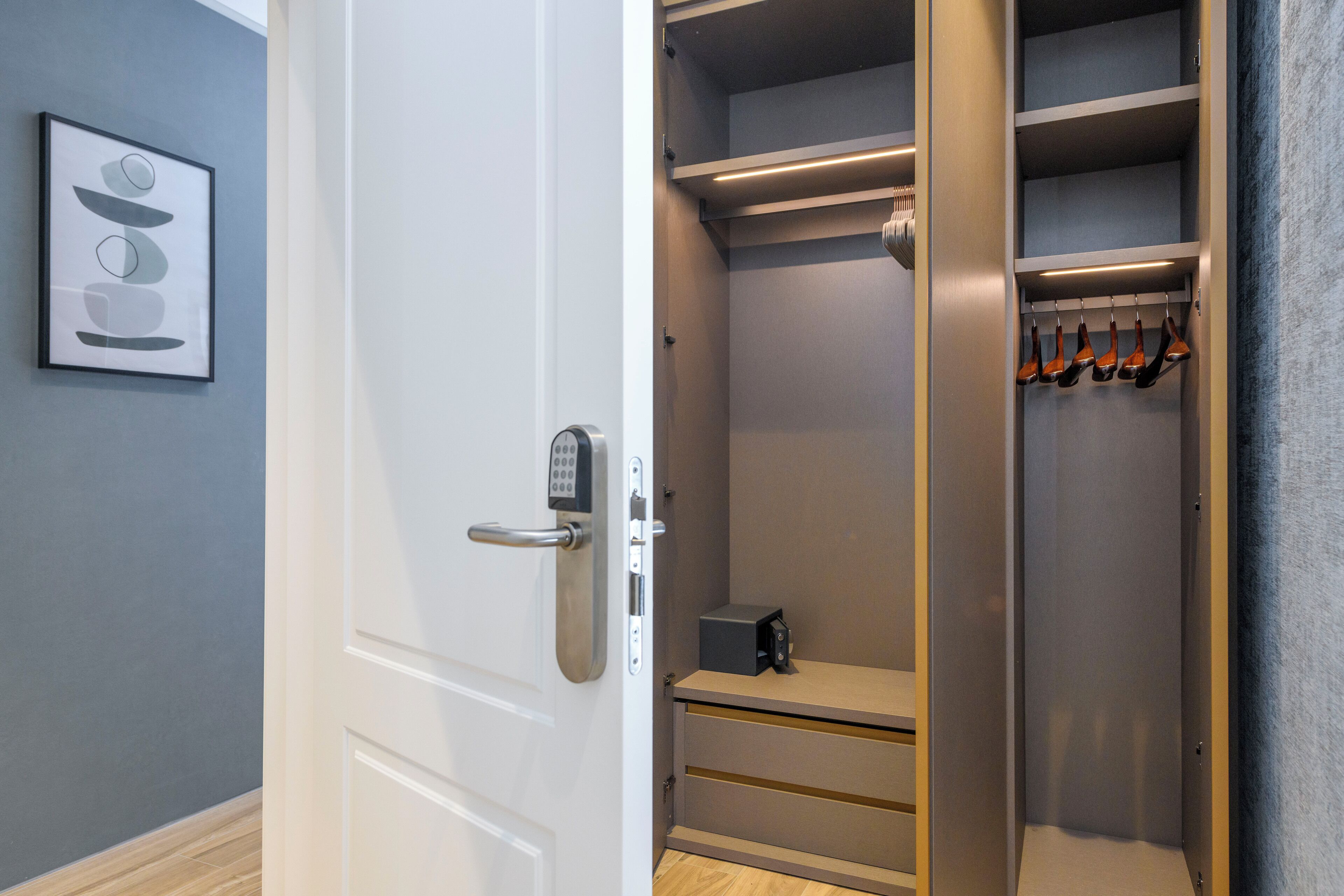 Un dressing accessible sans porte, doté d’une porte à combinaison, d’étagères et d’un porte-chaussures.