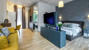 Una habitación de hotel moderna con una cama grande, televisión, sofá y escritorio.