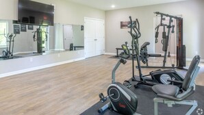 A gym with cardio machines, weightlifting equipment, and a mirror wall. - Stonecrest 701, 2Bd Apt I Free Parking I Pool (New Albany)