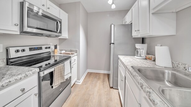 A modern kitchen with stainless steel appliances, white cabinetry, and granite countertops. - Stonecrest 713, 2Bd Apt I Free Parking I Pool (New Albany)