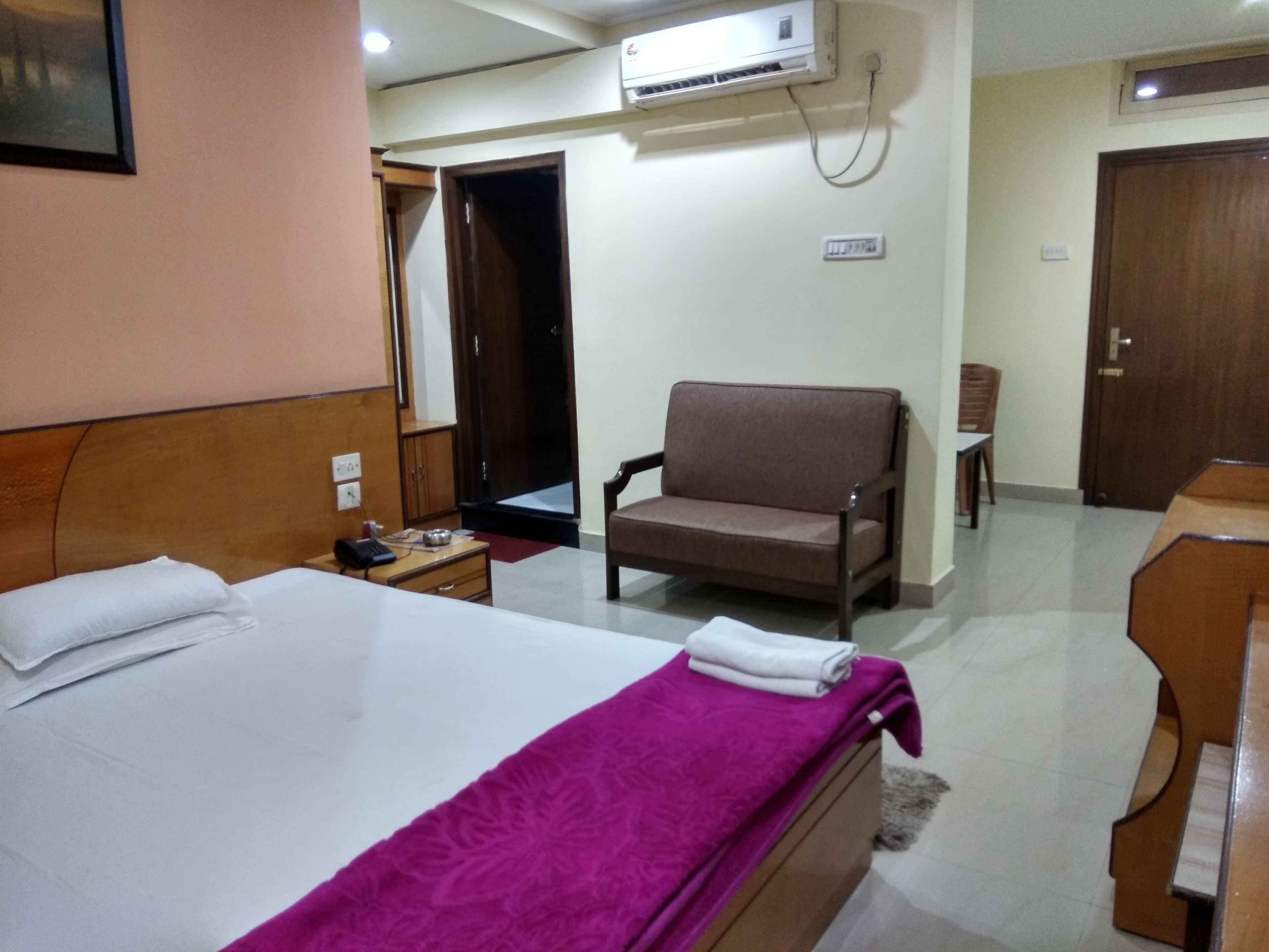 Une chambre d’hôtel équipée d’un lit, d’une chaise, d’un bureau et d’un appareil de climatisation.