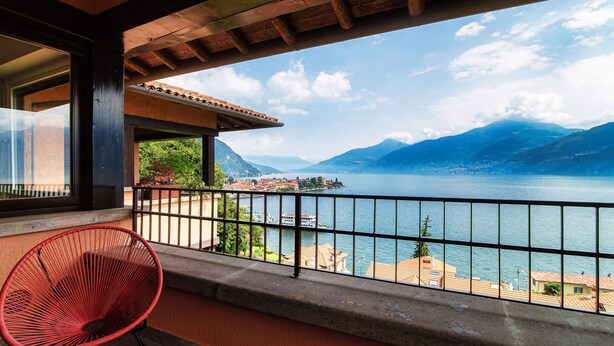 Ein Balkon mit Blick auf einen See und Berge.
