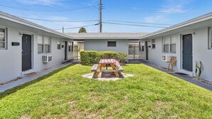 Un motel de dos pisos con un patio central que incluye una mesa de picnic.