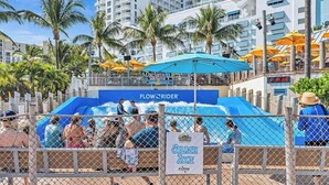 Zona acuática de parque con un letrero que indica una 'Splash Zone' y una atracción 'FlowRider'.