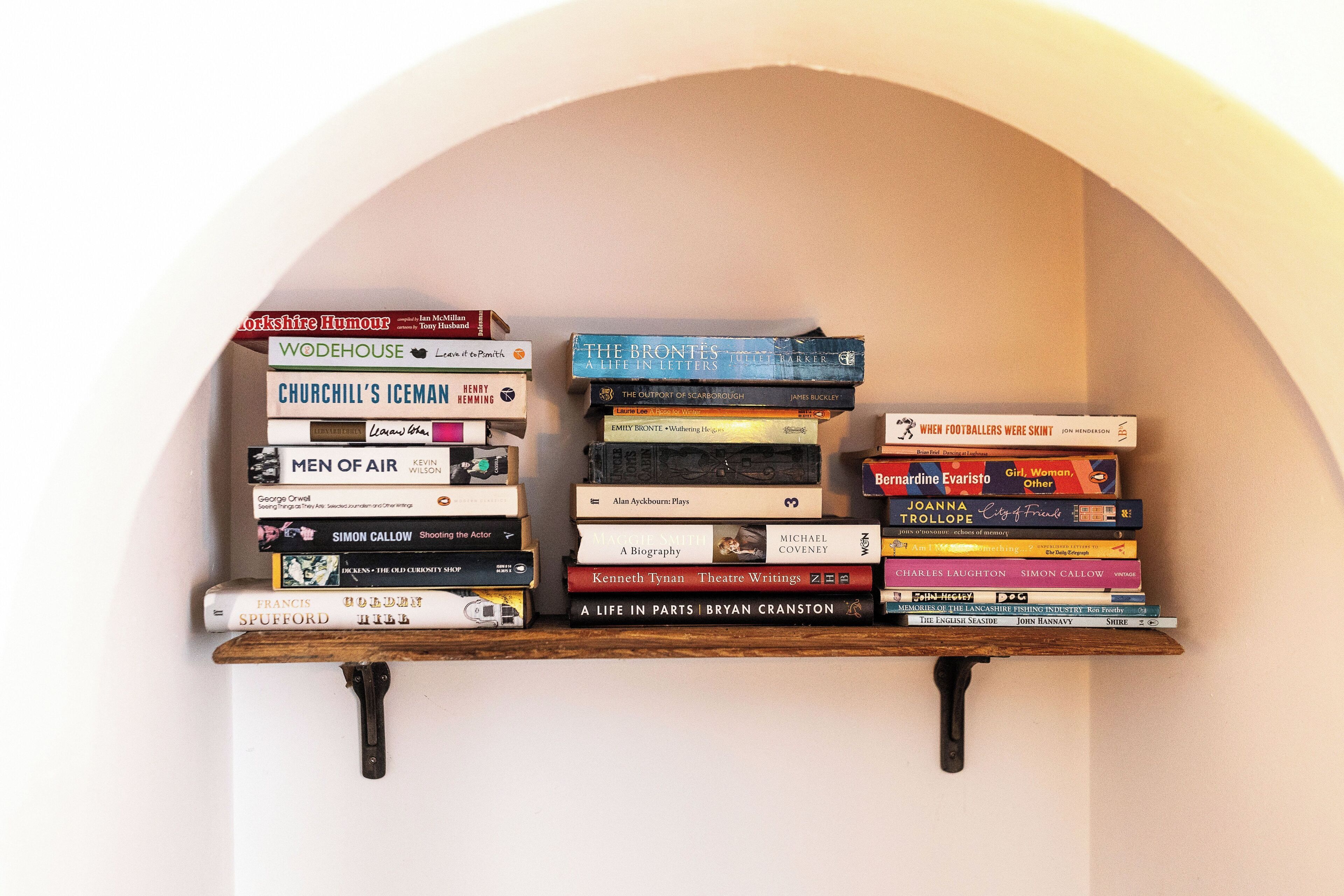 A bookshelf with a variety of books, including titles like 'Men of Air' and 'The Brontes'.