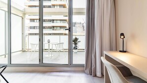En moderne lejlighed med en skydedør til en balkon, et lille bord og en stol.