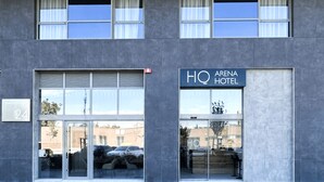 Et moderne hotel med en glasfacade, parkeringsplads og uhindret udsigt til gaden.