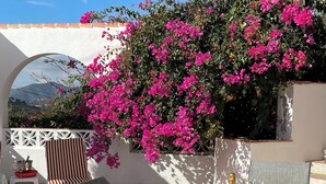 An outdoor patio with a table set for two, a bottle of champagne, and a chair. - Superior 2-Bedroom boutique apartment with Stunning Views & Modern Amenities (Cómpeta)