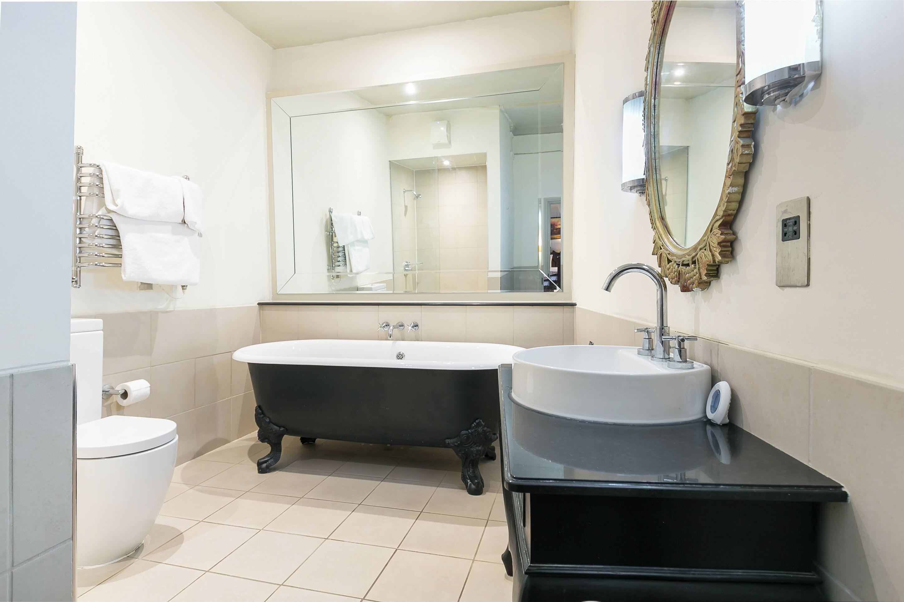 A bathroom with a toilet, a bathtub, and a sink.