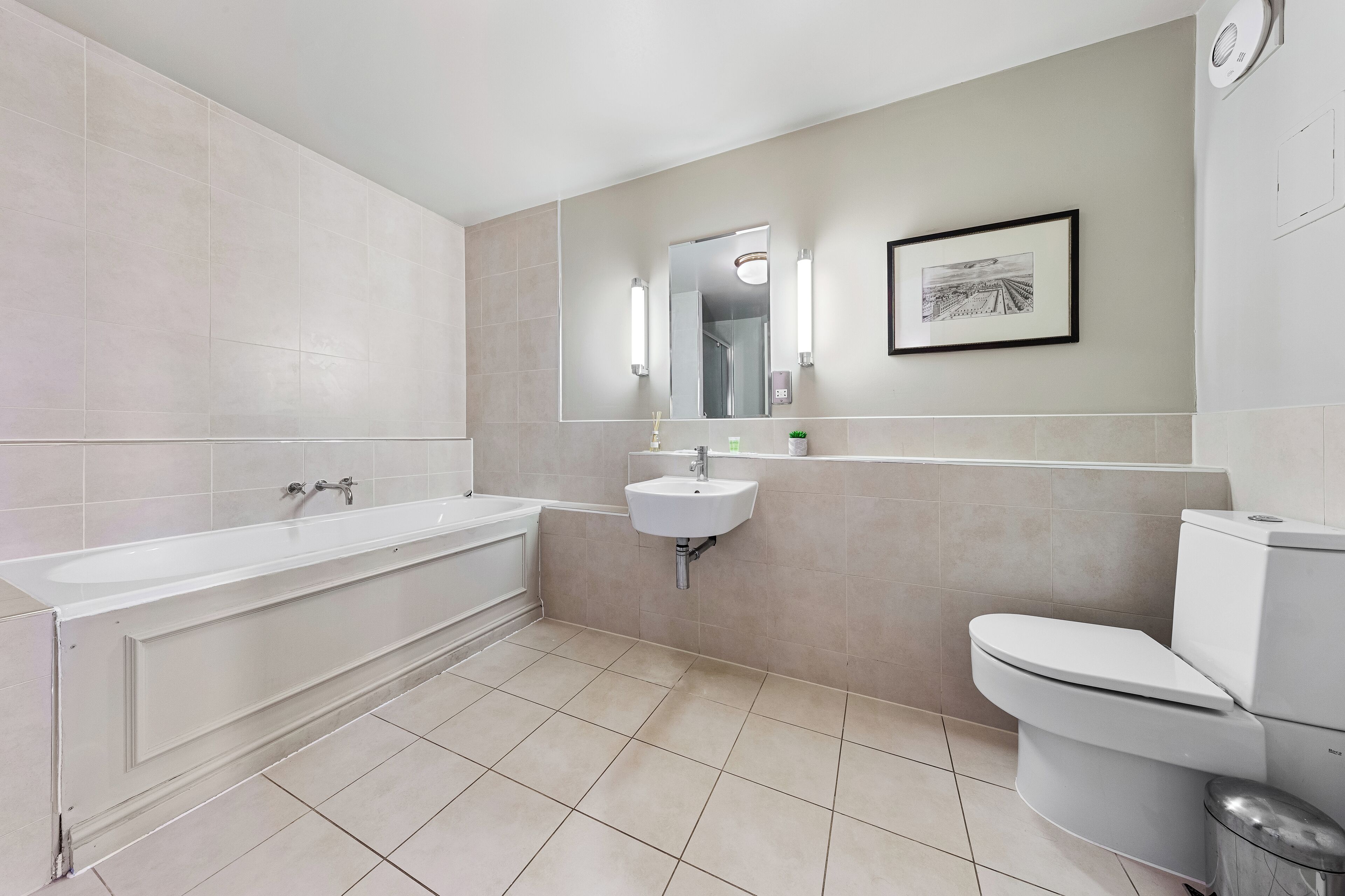 A modern bathroom with a bathtub, sink, and toilet.
