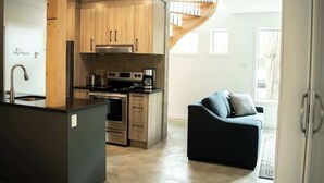 Una cocina moderna con armarios de madera, electrodomésticos de acero inoxidable y una isla con encimera negra.
