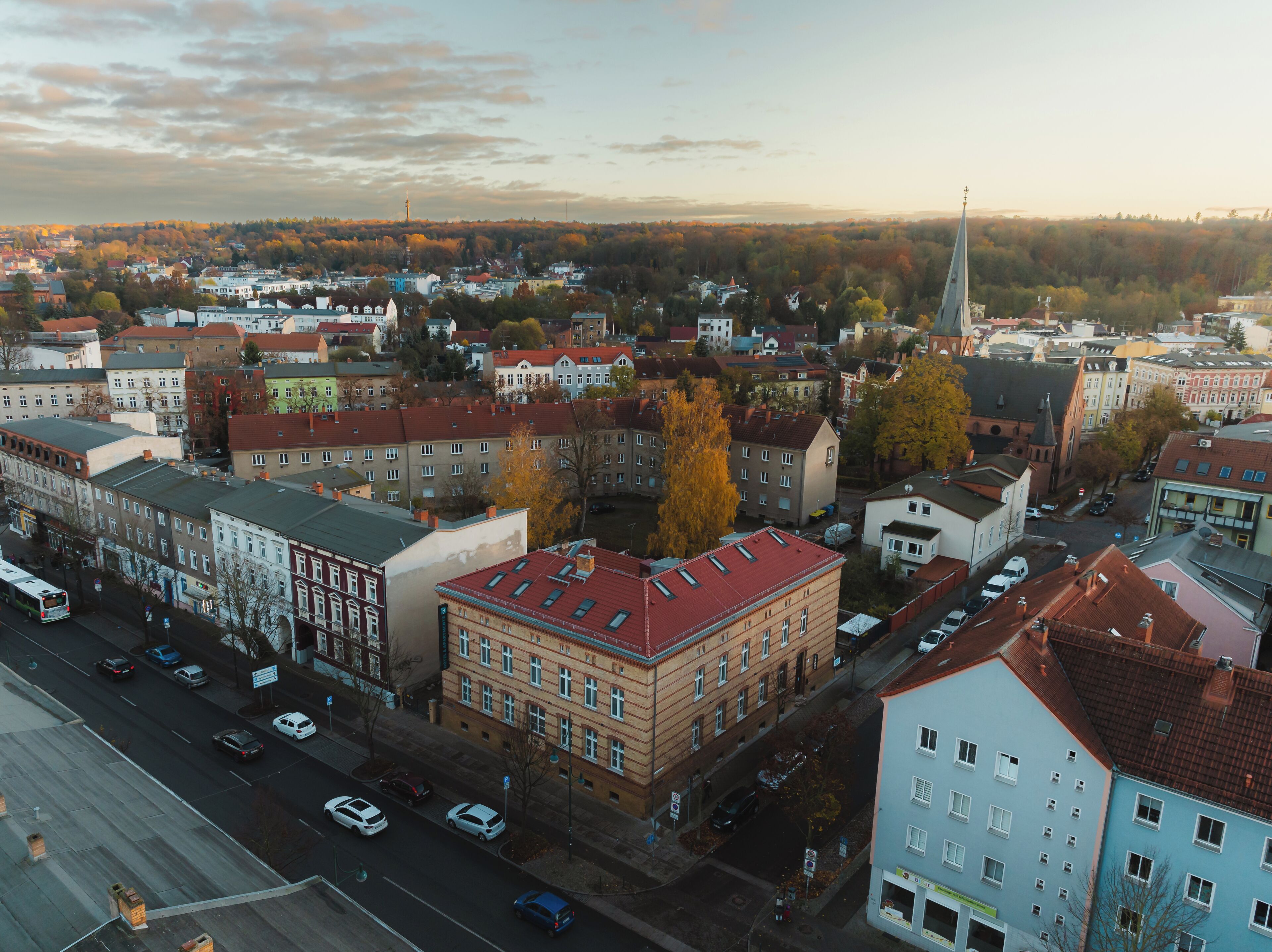 Eine Luftaufnahme einer Stadtlandschaft mit verschiedenen Gebäuden, Straßen und einem Kirchturm.