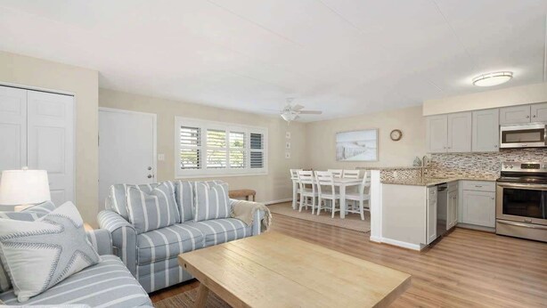 A modern living room with a sofa, coffee table, and dining area. - Ocean Block-Uptown -Northside Park-Sleeps 6 (Ocean City)