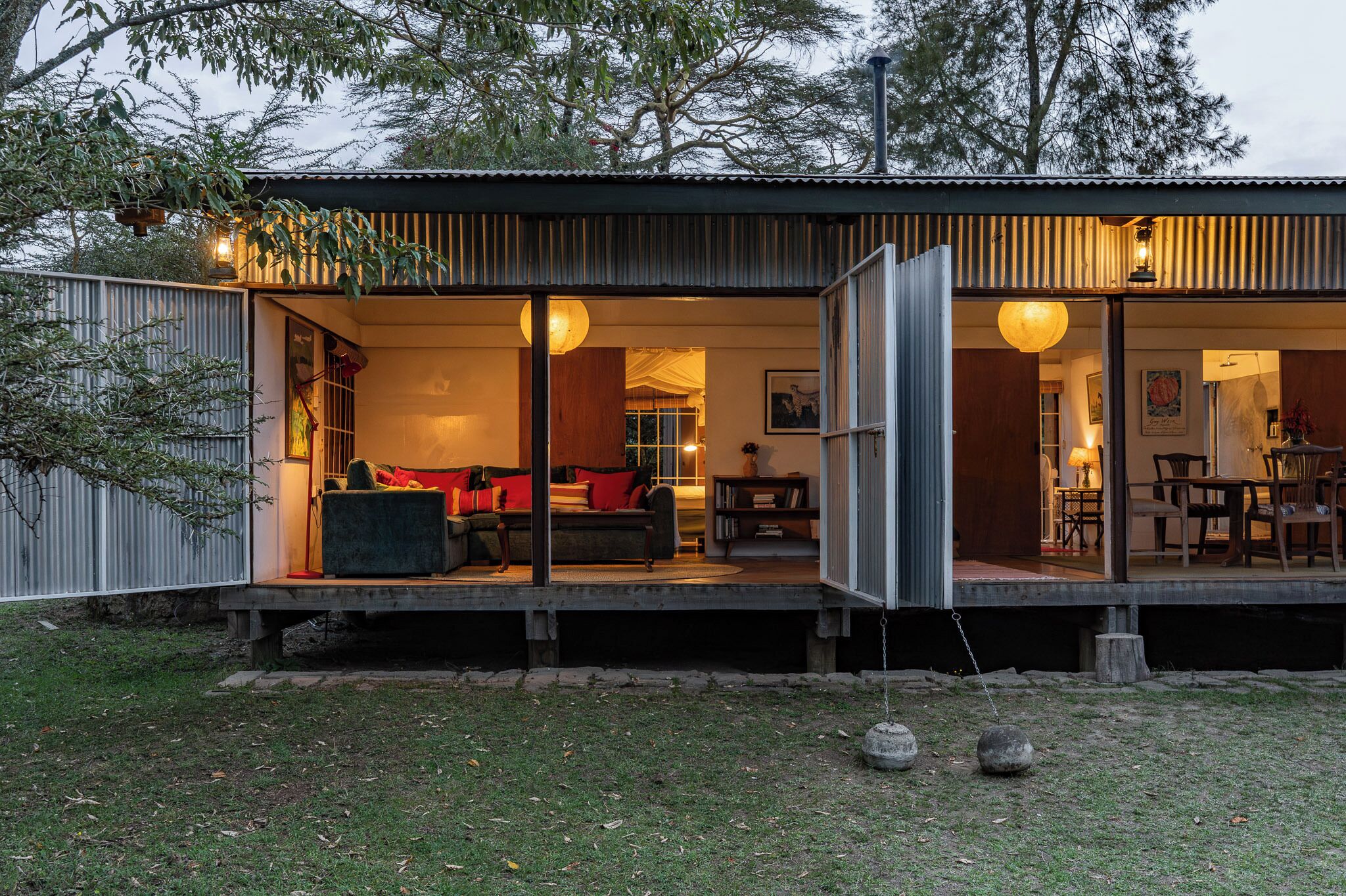 Een modern huis met een overdekte veranda, een eethoek en een woonkamer met een bank en kussens.