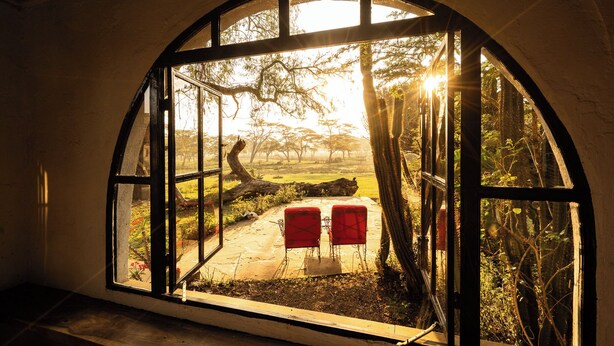 Una habitación con un amplio ventanal abovedado que da a un jardín.