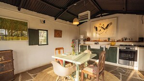 Un comedor con una mesa, sillas y una cocina al fondo.