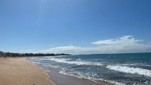 A beach with a clear sky and calm sea. - Appartement à Louer Garden Paradise Bouznika (bouznika)