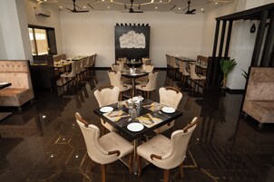 Uma sala de jantar com uma grande mesa redonda posta para seis pessoas, rodeada por seis cadeiras.