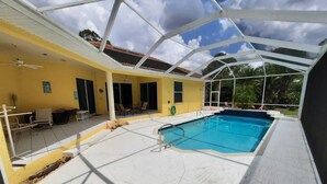 Una piscina interior con techo de vidrio, paredes amarillas y suelo de baldosas.
