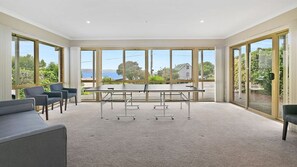 A conference room with a large table, chairs, and large windows offering a view of the outdoors. - Majestic Views (Marengo)