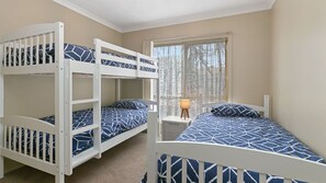 A room with bunk beds and a window with curtains.