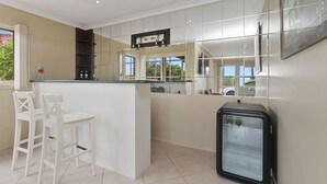 Una cocina con barra, refrigerador y ventana con vistas.
