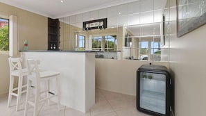 A kitchen with a bar area, a refrigerator, and a window with a view. - Majestic Views (Marengo)