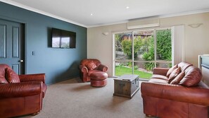 A living room with two leather sofas, a brown leather armchair, and a wooden coffee table. - Majestic Views (Marengo)