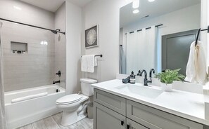 Une salle de bain moderne équipée d’une baignoire, de toilettes et d’un lavabo.