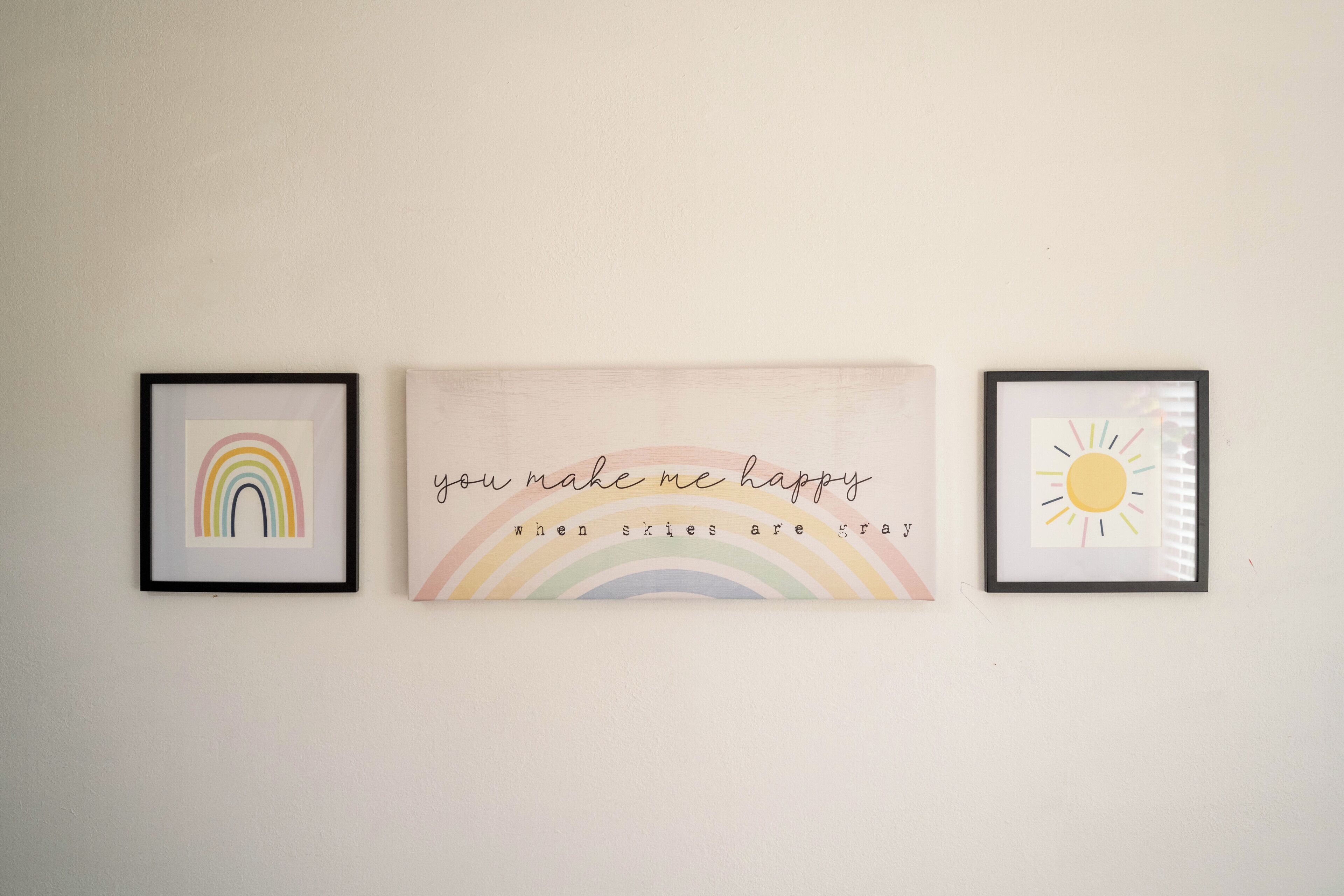 Trois œuvres d’art encadrées sont accrochées au mur.