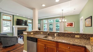 A modern kitchen with granite countertops, wooden cabinets, and a built-in dishwasher.