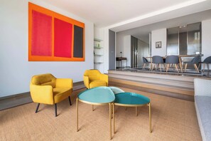 A modern living room with yellow armchairs, a coffee table, and a large abstract painting. - Elegant Paris Apartment on Avenue Montaigne (Paris)