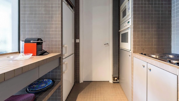 Een keuken met een magnetron, oven en een spoelbak.