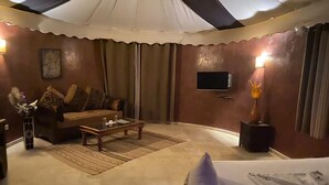 Ein Wohnzimmer mit Sofa, Couchtisch und einem an der Wand befestigten Fernseher.