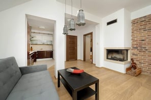 Uma sala de estar moderna com um sofá, uma mesa de centro e uma lareira.